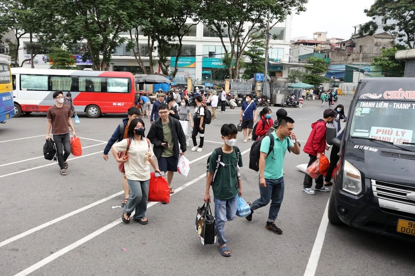 Người dân tay xách lỉnh kỉnh đồ đạc từ các tỉnh thành trở về Thủ đô trong ngày cuối của đợt nghỉ lễ 30/4-1/5. (Ảnh: Hoài Nam/Vietnam+)