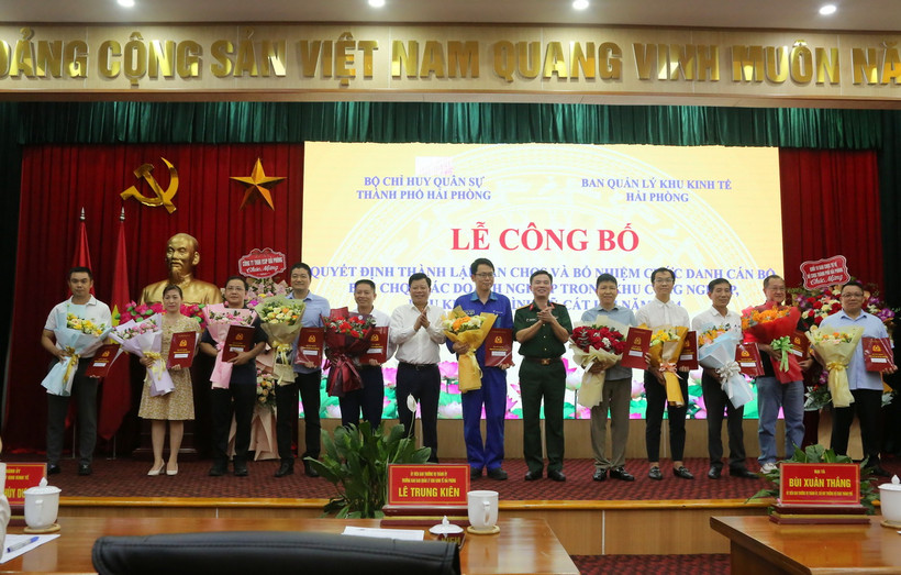 Ông Lê Trung Kiên, Trưởng ban Ban quản lý Khu kinh tế Hải Phòng (thứ 6 từ trái sang) và Đại tá Bùi Xuân Thắng (mặc quân phục) chúc mừng các doanh nghiệp. (Ảnh: Minh Thu/TTXVN)