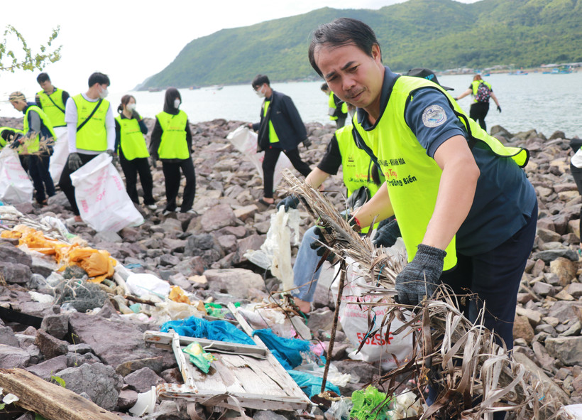 Nhân viên Ban Quản lý vịnh Nha Trang cùng các tình nguyện viên dọn rác tại khu vực bờ kè biển Vĩnh Trường, sát bến tàu du lịch Nha Trang. (Ảnh: Phan Sáu/TTXVN)