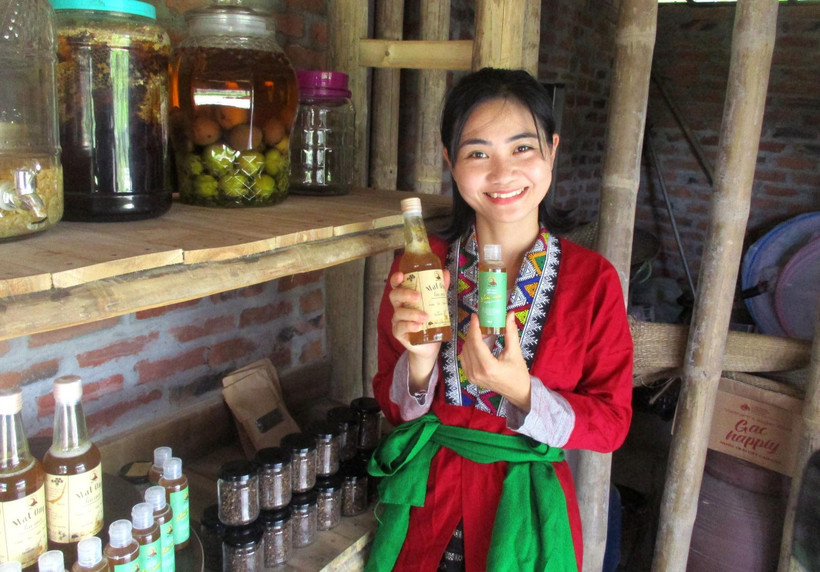 Chi Nguyễn Lê Ngọc Linh và sản phẩm mật ong sạch của Vườn rừng bản Thổ. (Ảnh: Nguyễn Nam/TTXVN)