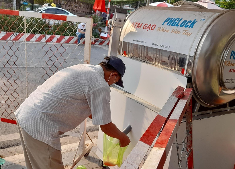 Người dân trong khu cách ly xếp hàng chờ lấy gạo từ cây ATM gạo. (Ảnh: Huyền Trang/TTXVN)