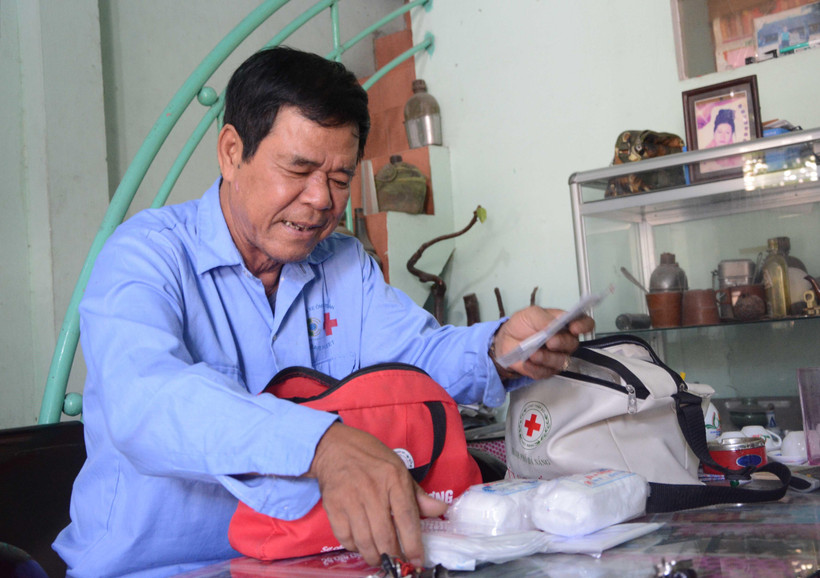 Ông Đặng Thanh Kinh, thành viên của đội "Xe ôm an toàn" thường xuyên kiểm tra túi sơ cứu. (Ảnh: Văn Dũng/TTXVN)