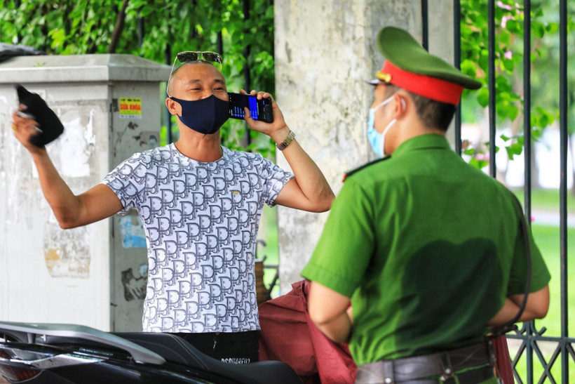 Công an phường Lê Đại Hành, Hà Nội xử lý nghiêm trường hợp ra đường không có việc thiết yếu sau nhiều lần đã nhắc nhở. (Ảnh: Thành Đạt/TTXVN)