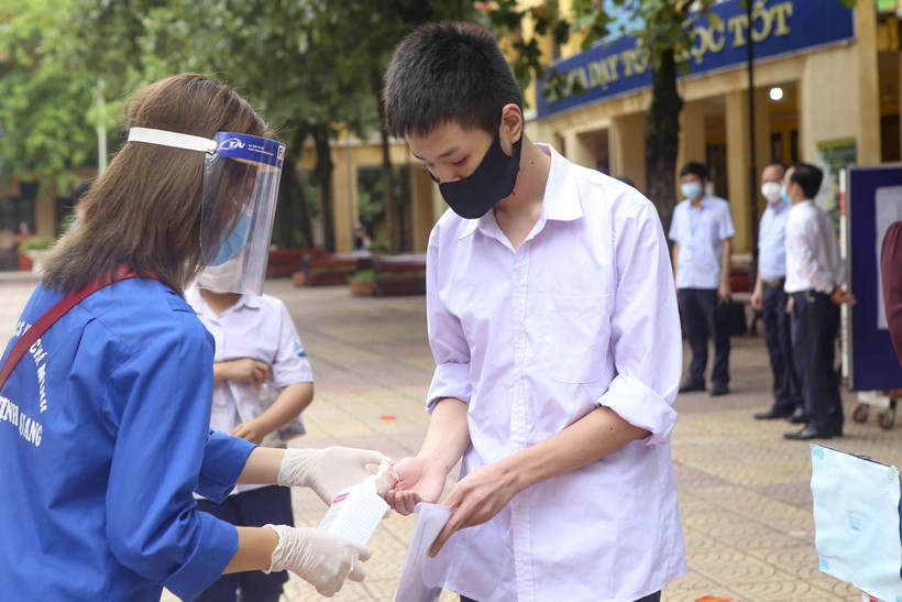 Thí sinh được sát khuẩn tay trước khi ra khỏi điểm thi. (Ảnh: Tuấn Đức/TTXVN)
