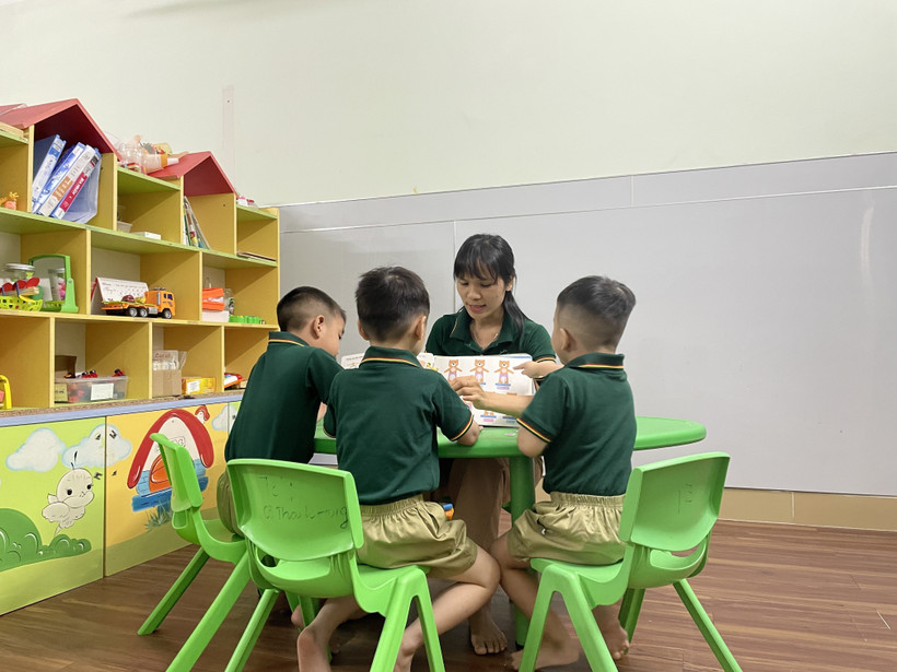 Cô Nguyễn Thị Mai, Giám đốc Trung tâm Hỗ trợ giáo dục hòa nhập trẻ tự kỷ Hoàng Đức (thành phố Biên Hòa, Đồng Nai) cùng chơi với trẻ tự kỷ trong tiết can thiệp cá nhân. (Ảnh: Lê Xuân/TTXVN)