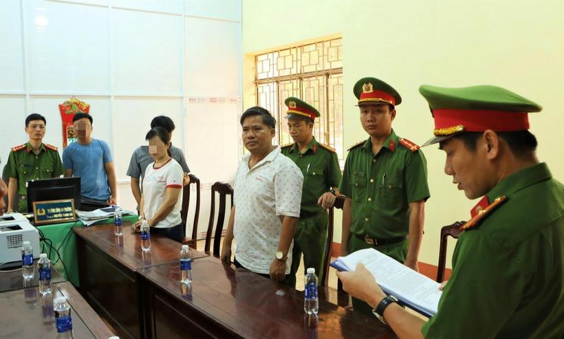 Cơ quan Công an thực hiện lệnh khởi tố bị can và bắt tạm giam đối với Nguyễn Hữu Hóa (áo trắng, bên phải). (Ảnh: TTXVN phát)