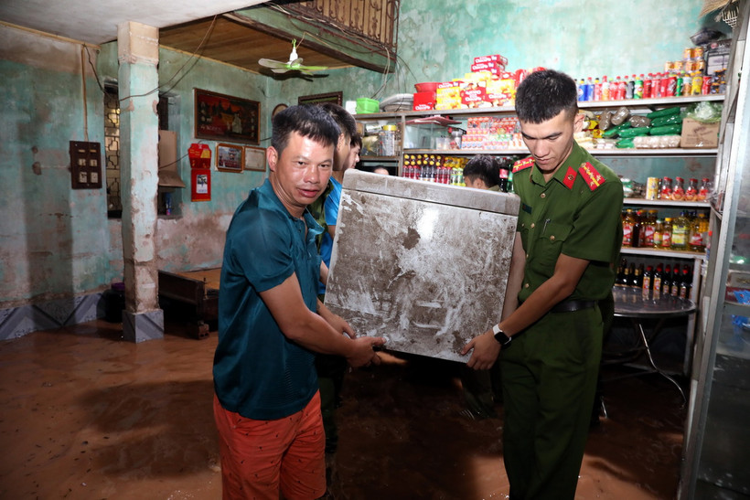 Lực lượng chức năng thành phố Lạng Sơn hỗ trợ gia đình bà Nguyễn Thị Hoa ở khu vực khối Cửa Bắc, phường Chi Lăng, thành phố Lạng Sơn di chuyển đồ đạc đến nơi an toàn. (Ảnh: Văn Đạt/TTXVN)