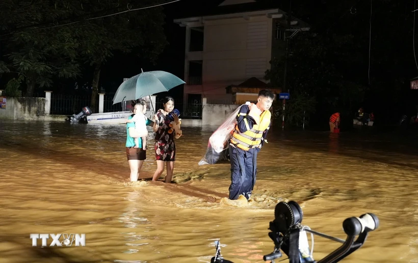 Lực lượng công an thành phố Yên Bái giúp người dân phường Hồng Hà di chuyển ra khỏi khu vực ngập úng trong đêm ngày 8/9. (Ảnh: TTXVN phát)