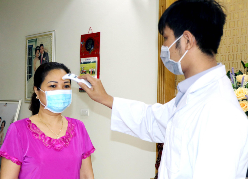 Nhân viên tế Trạm y tế phường Hồng Hà khám sức khỏe tại gia đình số nhà 18, đường Đặng Thùy Châm, thành phố Hạ Long. (Ảnh: Văn Đức/TTXVN)