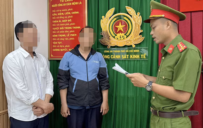 Cơ quan chức năng Công an Thành phố Hồ Chí Minh thực hiện quyết định khởi tố bị can, ra lệnh bắt tạm giam Hồ Việt Tân (trái) và Bùi Huỳnh Bá Phước (giữa). (Ảnh: TTXVN phát)