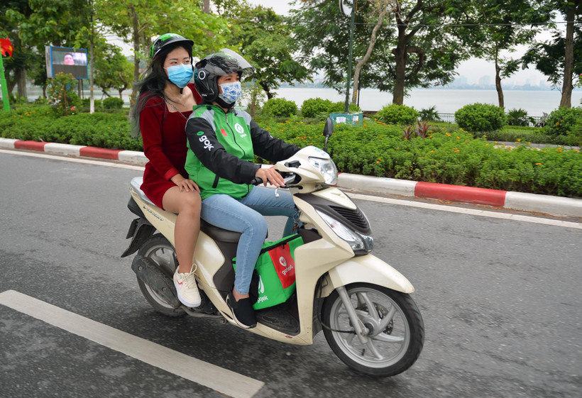 Nhu cầu di chuyển và đặt thức ăn trực tuyến gia tăng, nghề xe ôm công nghệ cũng có thêm đất sống. (Ảnh: CTV/Vietnam+)