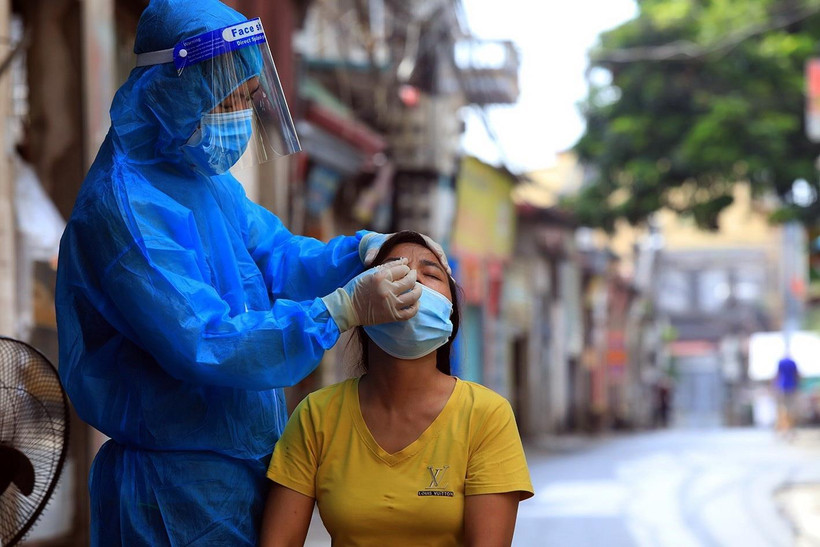 Người dân được cán bộ y tế lấy mẫu xét nghiệm COVID-19. (Ảnh: Tuấn Anh/TTXVN)