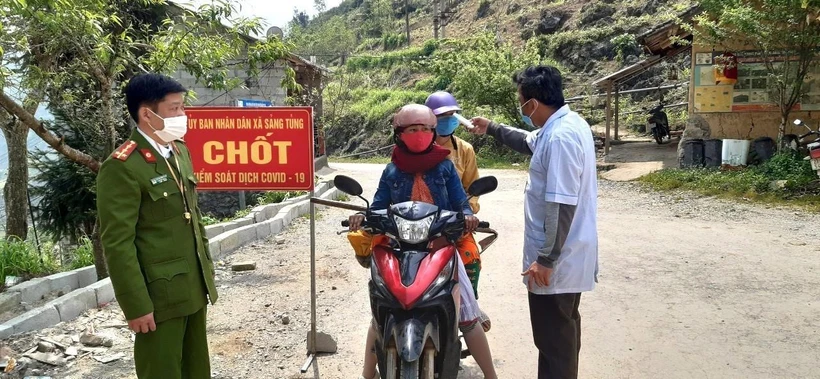Lực lượng y tế đo thân nhiệt nhân dân tại chốt kiểm soát xã Sảng Tủng, huyện Đồng Văn (Hà Giang). (Ảnh: TTXVN phát)