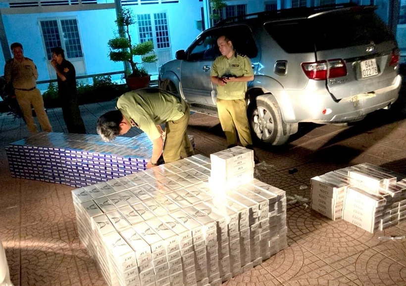 Lực lượng chức năng kiểm tra và tạm giữ số thuốc lá điếu nhập lậu. (Ảnh: Lê Thúy Hằng/TTXVN)