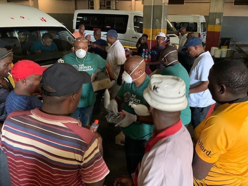 Nhân viên y tế phát dung dịch khử trùng tay tại một bến xe khách tại thủ đô Pretoria, Nam Phi. (Ảnh: Phi Hùng/TTXVN)