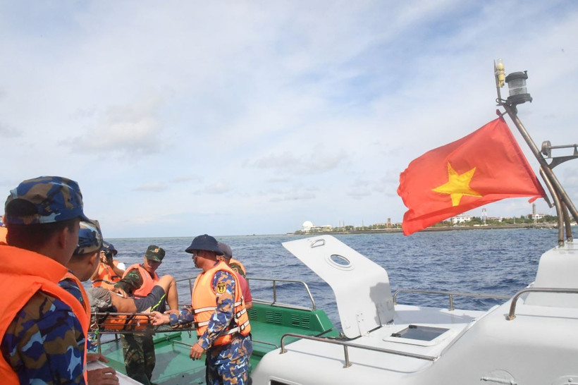 Tàu 471 tiến hành thủ tục bàn giao ngư dân Phan Kiệt cho đảo Song Tử Tây để đưa lên bờ điều trị. (Ảnh: TTXVN phát)