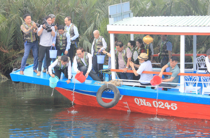 Các đại biểu tham gia thả cá giống tại vùng nước tự nhiên ở khu vực Hội An, tỉnh Quảng Nam. (Ảnh: PV/Vietnam+)