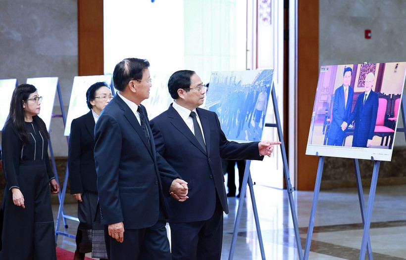 Thủ tướng Phạm Minh Chính giới thiệu với Tổng Bí thư, Chủ tịch nước Lào Thongloun Sisoulith một số hình ảnh về hoạt động đối ngoại của Tổng Bí thư Nguyễn Phú Trọng. (Ảnh: Dương Giang/TTXVN)