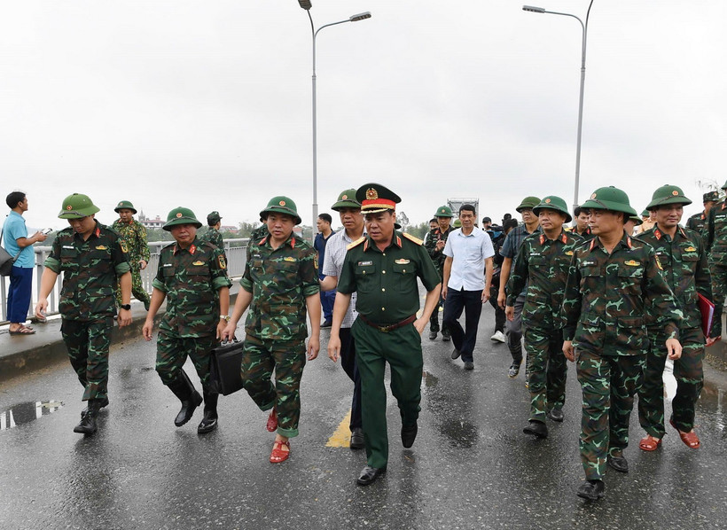 Trung tướng Phạm Đức Duyên, Bí thư Đảng ủy, Chính ủy Quân khu 2 và đại diện các đơn vị khảo sát vị trí lắp cầu phao. (Ảnh: TTXVN phát)