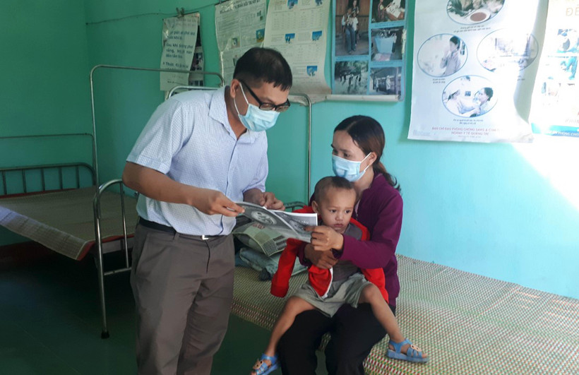 Cán bộ y tế địa phương phát tờ rơi tuyên truyền về bệnh bạch hầu để người dân phòng tránh. (Ảnh: Hồ Cầu/TTXVN)