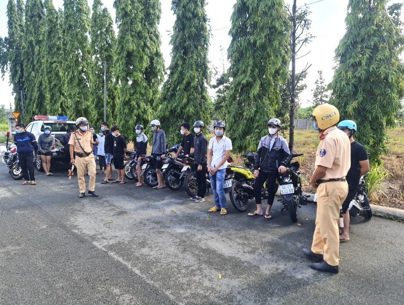 Các “quái xế” cùng phương tiện tụ tập đua xe, cổ vũ đua tại Khu công nghiệp Biên Hòa 2 bị tạm giữ ngày 4/7. (Ảnh: TTXVN phát)