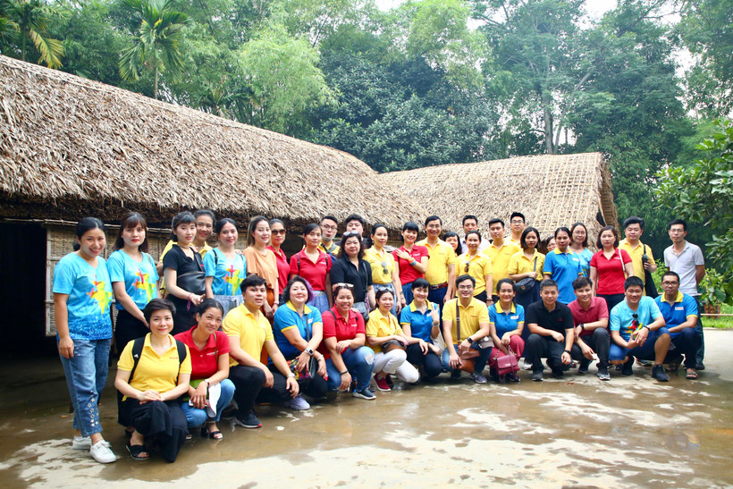Tập thể ban lãnh đạo và cán bộ nhân viên Báo điện tử VietnamPlus chụp ảnh lưu niệm trước ngôi nhà của cụ Phó bảng Nguyễn Sinh Sắc ở làng Sen. (Ảnh: Nguyễn An/Vietnam+)