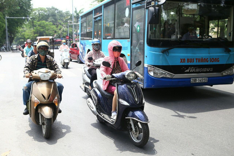 Người dân trang bị từ đầu đến chân để chống chọi lại cái nắng rát của mặt đường phả lên. (Ảnh: Danh Lam/TTXVN)