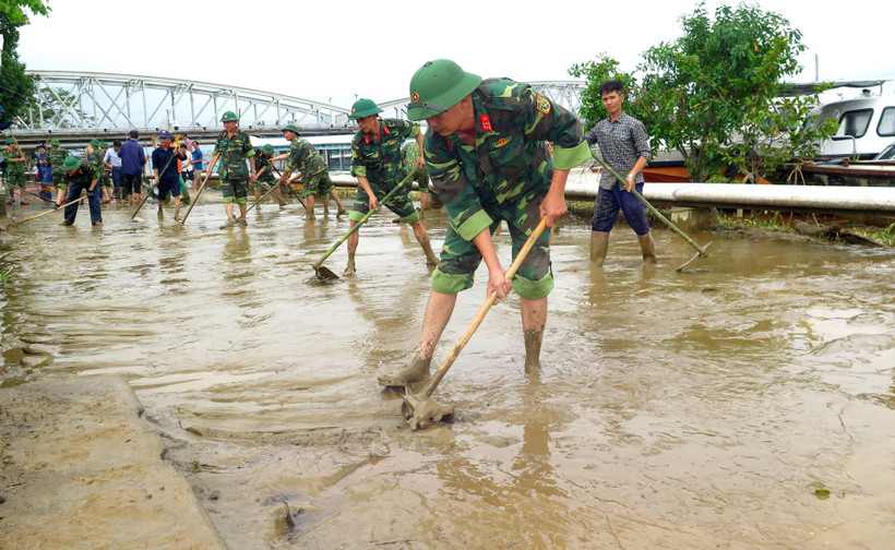 Cán bộ, chiến sỹ cùng người dân khẩn trương dọn vệ sinh sau mưa lũ tại Thừa Thiên-Huế. (Ảnh: Tường Vi/TTXVN)