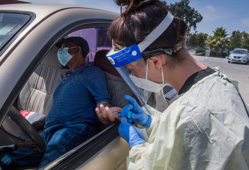 Nhân viên y tế lấy mẫu xét nghiệm COVID-19 cho người dân tại Inglewood, California (Mỹ). (Ảnh: AFP/TTXVN)