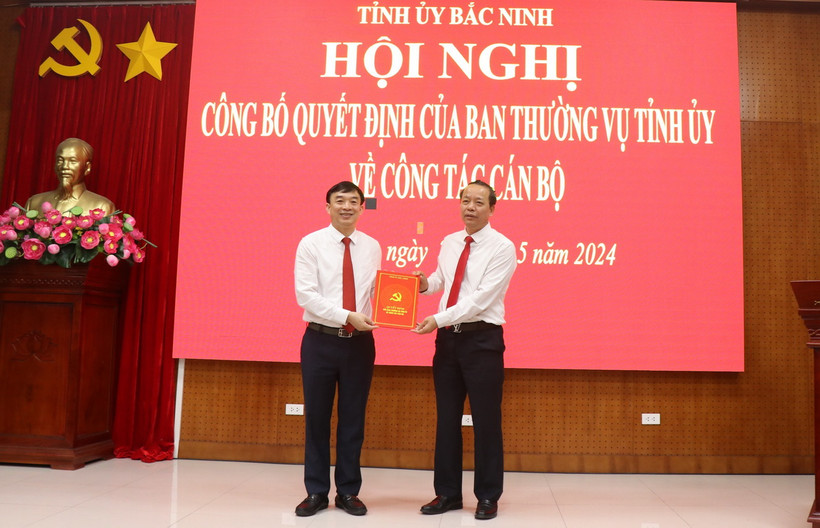 Phó Bí thư Thường trực Tỉnh ủy, Chủ tịch Hội đồng Nhân dân tỉnh Bắc Ninh Nguyễn Quốc Chung (phải) trao Quyết định của Ban Thường vụ Tỉnh ủy Bắc Ninh cho ông Nguyễn Đình Lợi. (Ảnh: Thanh Thương/TTXVN)