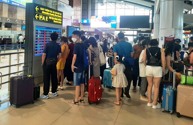 Hành khách theo dõi lịch bay của hãng hàng không tại sân bay Nội Bài. (Ảnh: Việt Hùng/Vietnam+)