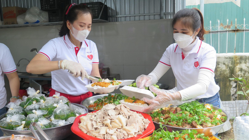 Nhóm Thiện Tâm chuẩn bị các phần cơm cho người có hoàn cảnh khó khăn. (Ảnh: Tường Vi/TTXVN)