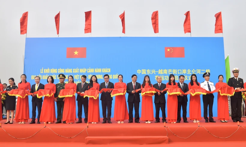 Đại diện lãnh đạo hai tỉnh Quảng Ninh (Việt Nam) và Quảng Tây (Trung Quốc) cắt băng khởi động công năng xuất nhập cảnh hành khách qua Cửa khẩu Quốc tế Móng Cái (khu vực cầu Bắc Luân 2). (Ảnh: Thanh Vân/TTXVN) 