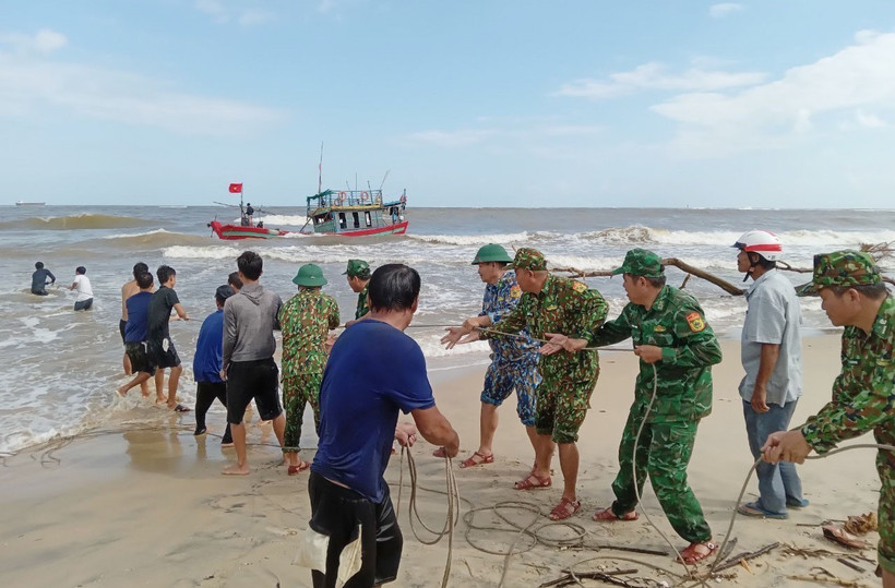 Bộ đội Biên phòng tỉnh Quảng Trị hỗ trợ ngư dân cố định tàu cá mắc cạn. (Ảnh: TTXVN phát) 