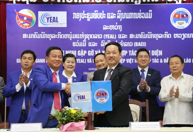 Chủ tịch BACI Nguyễn Thế Hiền (phải) và Chủ tịch YEAL Khamsen Sisavong trao văn kiện ký kết hợp tác. Ảnh: Xuân Tú/TTXVN)
