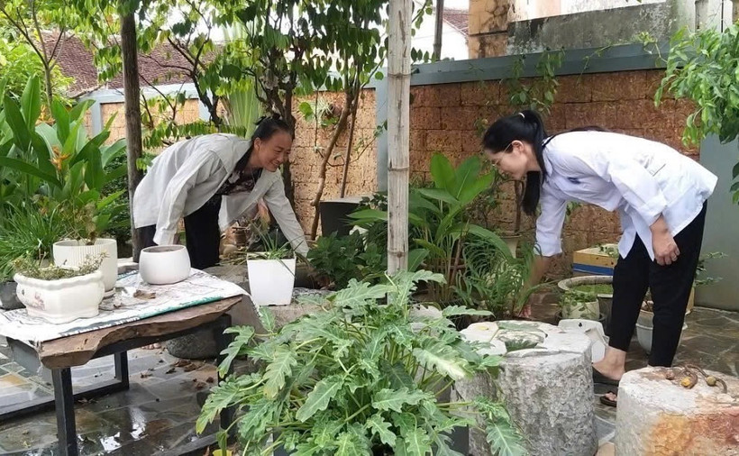 Cán bộ y tế xã Hòa Lâm, huyện Ứng Hòa, hướng dẫn người dẫn vệ sinh môi trường sau nước rút tại hộ gia đình. (Ảnh: TTXVN phát)