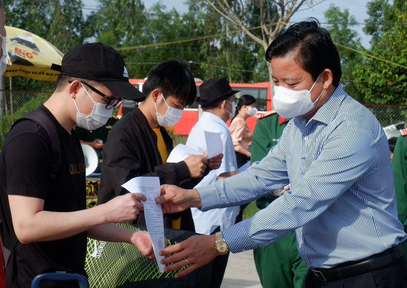 Phó Chủ tịch Ủy ban Nhân dân tỉnh Long An Phạm Tấn Hòa trao giấy xác nhận hoàn thành thời gian cách ly cho các công dân. (Ảnh: Đức Hạnh/TTXVN)