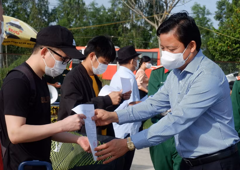 Phó Chủ tịch Ủy ban Nhân dân tỉnh Long An Phạm Tấn Hòa trao giấy xác nhận hoàn thành thời gian cách ly cho các công dân. (Ảnh: Đức Hạnh/TTXVN)
