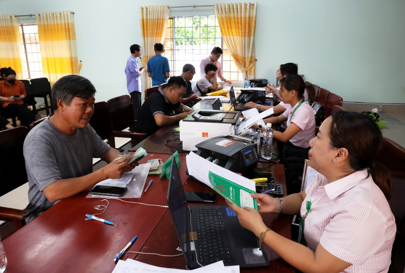 Người dân vay vốn chính sách từ Ngân hàng Chính sách xã hội trong phiên giao dịch tổ chức hàng tháng tại Điểm giao dịch xã La Ngà, huyện Định Quán, tỉnh Đồng Nai. (Ảnh: Hồng Đạt/TTXVN)