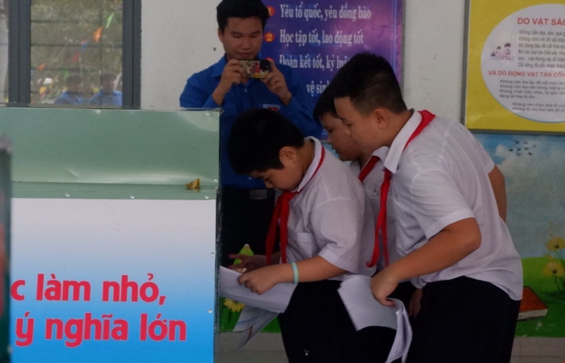 Các bạn nhỏ thực hiện phân loại rác. (Ảnh: Văn Dũng/TTXVN)