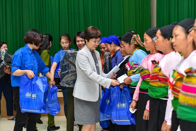 Bà Ninh Hồng Nga, Tổng Biên tập Báo Tin tức trao quà của chương trình "Đồng hành cùng vùng khó" cho chị em phụ nữ nghèo xã Điền Quang, huyện Bá Thước. (Ảnh: Hoa Mai/TTXVN)