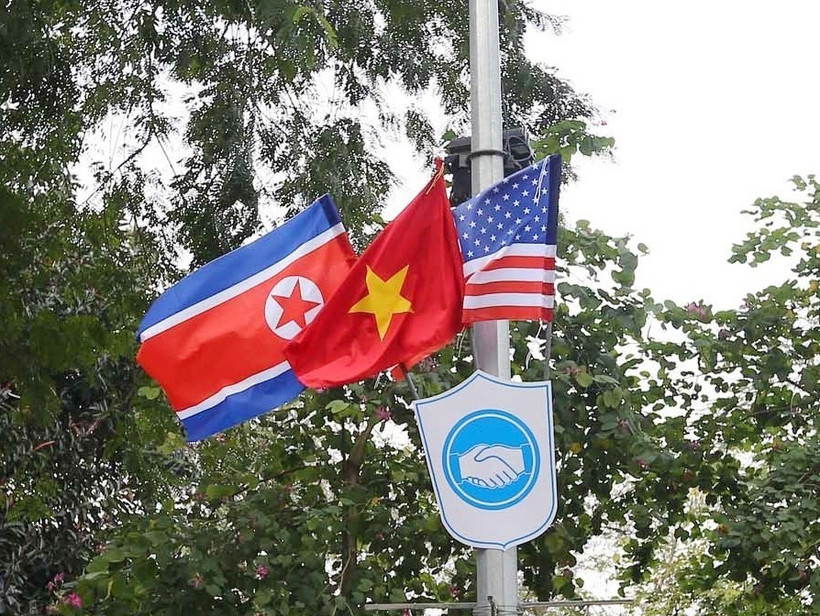 Cờ Mỹ, cờ Triều Tiên và cờ Việt Nam, bên dưới là biểu tượng hai bàn tay bắt chặt vào nhau thể hiện tinh thần của cuộc gặp lớn được treo trên các tuyến phố xung quanh hồ Hoàn Kiếm. (Ảnh: Danh Lam/TTXVN)