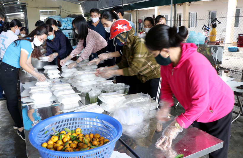 Chị em phụ nữ xã Thịnh Lộc, huyện Lộc Hà (Hà Tĩnh) chuẩn bị cơm, nước phục vụ người được cách ly. Ảnh: Công Tường/TTXVN)