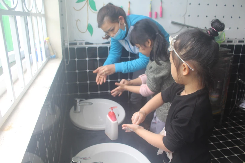 Hướng dẫn trẻ rửa tay bằng xà phòng để phòng chống COVID-19. (Ảnh: Hoa Mai/TTXVN)