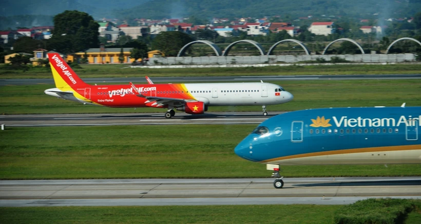 Máy bay của hai hãng hàng không Vietnam Airlines và Vietjet đang chuẩn bị cất, hạ cánh tại một sân bay. (Ảnh: PV/Vietnam+)