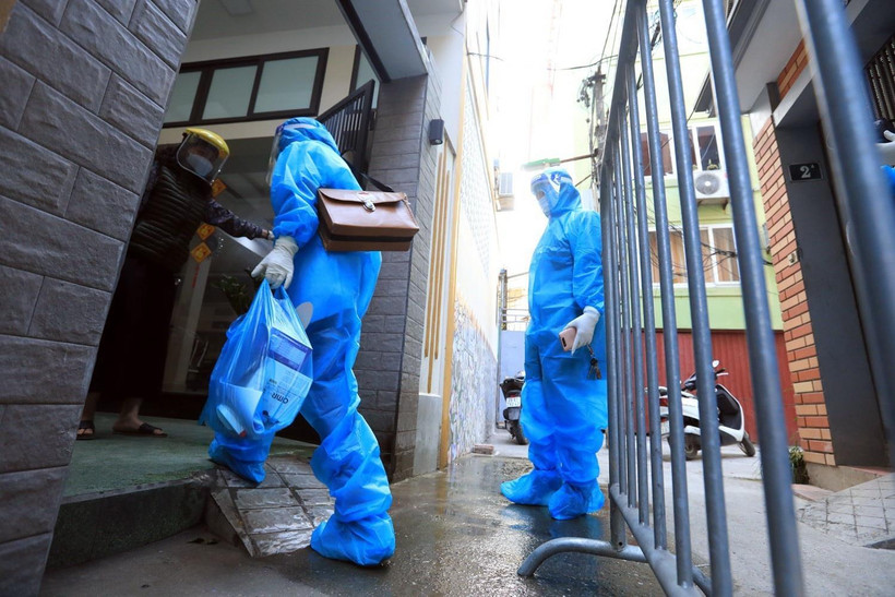 Nhân viên y tế xã Tam Hiệp, huyện Thanh Trì đến kiểm tra sức khỏe và phát thuốc cho trường hợp F0 đang điều trị tại nhà. (Ảnh: Tuấn Anh/TTXVN)