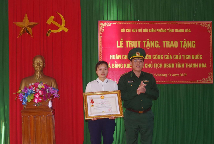 Vợ thiếu tá Vi Văn Nhất đón nhận Huân chương Chiến công hạng Nhất. (Ảnh: Trịnh Duy Hưng- TTXVN)