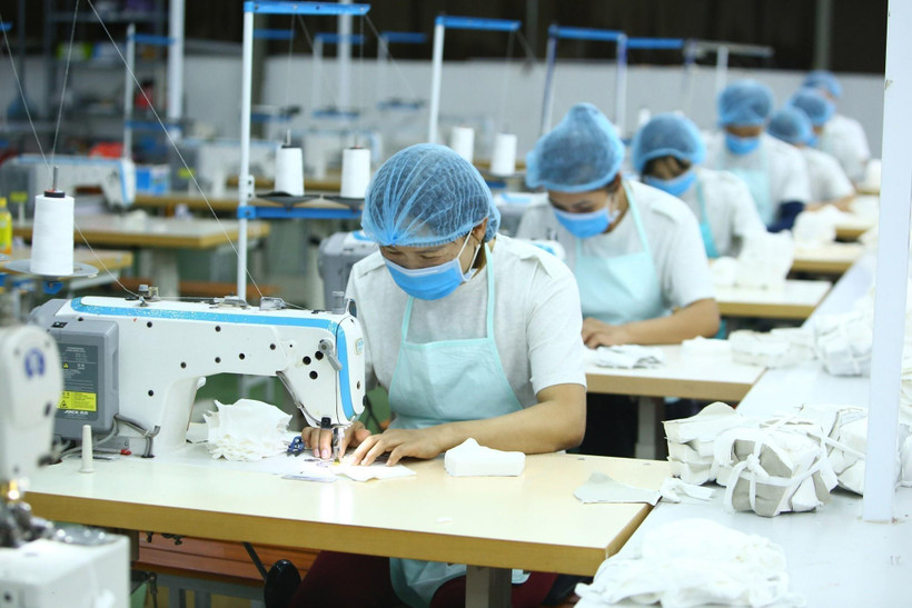 Công nhân Công ty Cổ phần Thời trang K’s Closet (Hà Nội) sản xuất khẩu trang kháng khuẩn. (Ảnh: Anh Tuấn/TTXVN)