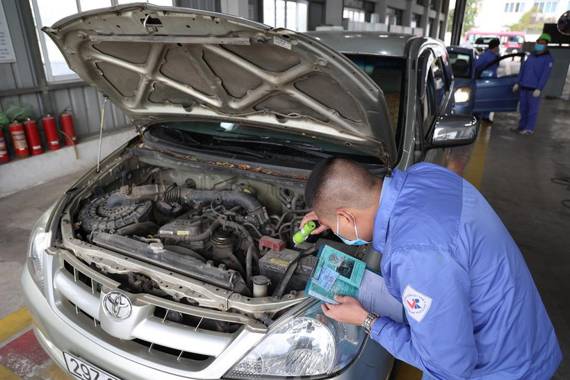 Nhân viên đăng kiểm thực hiện kiểm định phương tiện. (Ảnh: Minh Hiếu/Vietnam+)