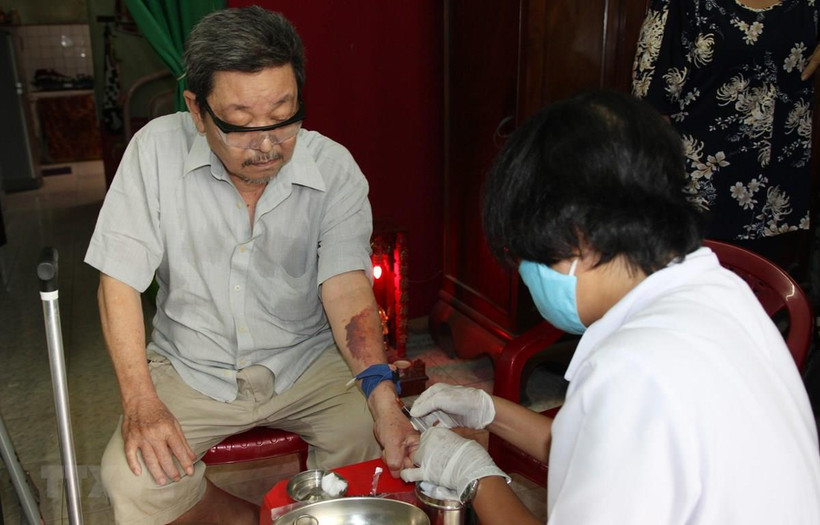 Điều dưỡng Trạm Y tế phường 16, quận Gò Vấp đến nhà lấy máu xét nghiệm cho người bệnh. (Ảnh: Đinh Hằng/TTXVN)